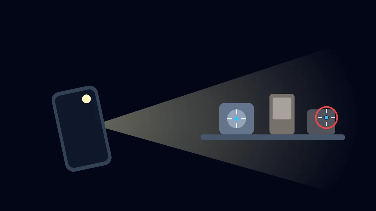 Phone torch revealing a hidden camera lens reflection in a dark room
